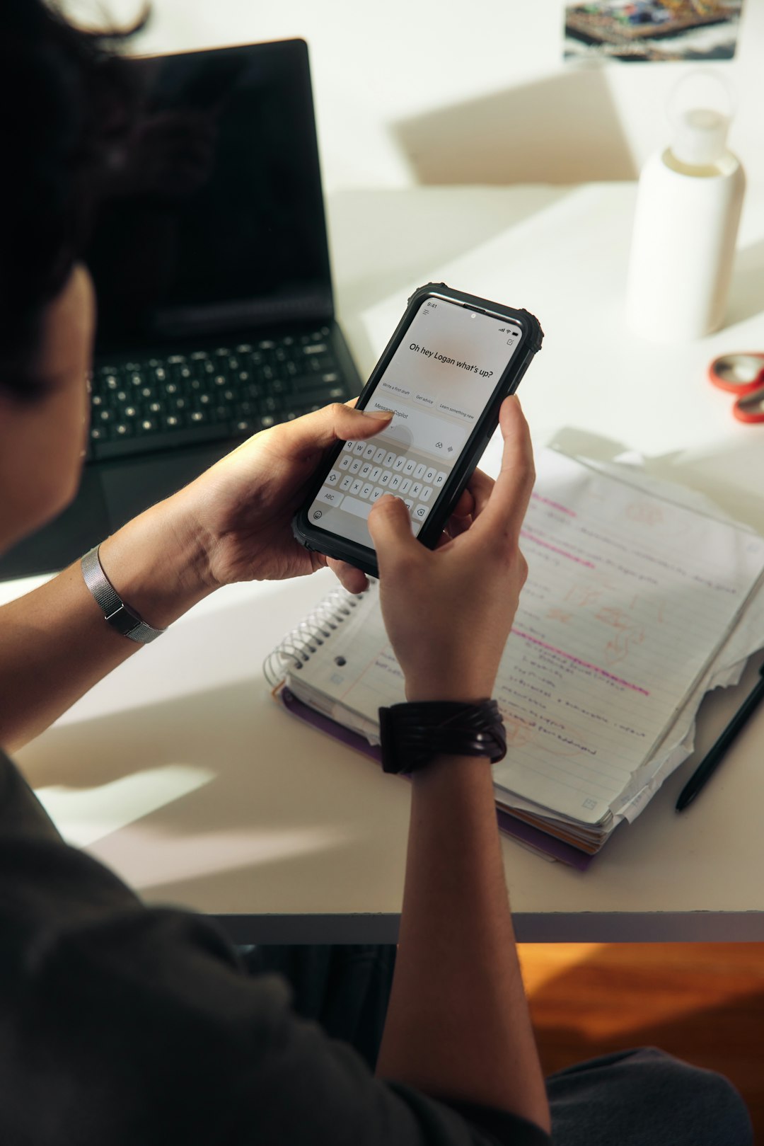 person-using-a-smartphone-over-a-notebook-quj8fgoaltg